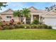 Beautiful front facade with double glass door entry, and a large, landscaped front lawn at 2902 Big Cypress Way, Wesley Chapel, FL 33544