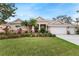 Charming single-story home features manicured lawn, three-car garage, and inviting landscaping at 2902 Big Cypress Way, Wesley Chapel, FL 33544