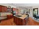Kitchen island with cooktop and seating, connected to a stone-accented living area at 2902 Big Cypress Way, Wesley Chapel, FL 33544