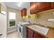 Functional laundry room with washer, dryer, sink, and storage cabinets at 2902 Big Cypress Way, Wesley Chapel, FL 33544