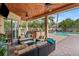 Covered patio with wood ceiling, comfortable seating, outdoor kitchen, and pool views at 2902 Big Cypress Way, Wesley Chapel, FL 33544