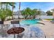 Backyard oasis with a beautiful pool, lush landscaping, and an outdoor fire pit at 2902 Big Cypress Way, Wesley Chapel, FL 33544