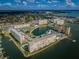 Aerial view of waterfront community with multiple buildings, pool, and tennis courts at 4550 Cove Cir # 804, St Petersburg, FL 33708