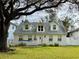 Charming two-story home with a white exterior, tree-lined yard, and a unique swing at 4826 W San Jose St, Tampa, FL 33629