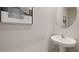 Small powder room with pedestal sink and round mirror at 515 Mangrove Shade Cir, Apollo Beach, FL 33572