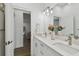 Double vanity bathroom with white cabinets and a view of the living room at 524 S Grosse Ave, Tarpon Springs, FL 34689