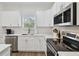 Modern kitchen with white cabinets, stainless steel appliances and an island at 524 S Grosse Ave, Tarpon Springs, FL 34689