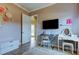 Stylishly furnished bedroom, with TV, desk, modern wall art, and doorway to a bright hallway at 6367 Foxbrook Trl, Parrish, FL 34219