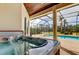 Close-up of hot tub on patio, with a view of the pool and screened-in lanai at 6367 Foxbrook Trl, Parrish, FL 34219
