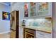 Wet bar off the kitchen with stainless steel refrigerator, wine cooler and custom cabinets at 6367 Foxbrook Trl, Parrish, FL 34219
