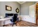 Home office with wood floors, natural light, three monitors, and a comfortable desk setup at 6367 Foxbrook Trl, Parrish, FL 34219