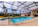 Relaxing screened-in pool with a jacuzzi and clear blue water surrounded by a spacious patio area with palm tree views at 6367 Foxbrook Trl, Parrish, FL 34219