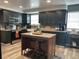 Modern kitchen with dark green cabinets, granite island, and stainless steel appliances at 6614 Papa Guy Ln, Plant City, FL 33565