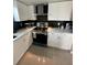 Updated kitchen with white cabinets, stainless steel appliances, and quartz countertops at 7524 Vienna Ln, Port Richey, FL 34668