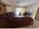 Living room with brown sectional sofa and view to backyard at 7524 Vienna Ln, Port Richey, FL 34668