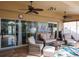 Cozy covered patio with wicker furniture, ceiling fans, and large art piece at 7702 Northaven Pl, Trinity, FL 34655