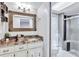 Updated bathroom with granite countertops, white cabinets, and a walk-in shower at 8532 Kumquat Ave, Seminole, FL 33777