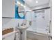 Clean bathroom with pedestal sink, tub, and a modern glass shower at 8532 Kumquat Ave, Seminole, FL 33777