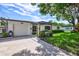 Inviting home exterior featuring a covered entryway, well-manicured lawn, and a two-car garage at 8532 Kumquat Ave, Seminole, FL 33777