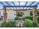 Elegant front entry with pergola, stone pillars, and lush landscaping at 8532 Kumquat Ave, Seminole, FL 33777