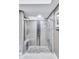 Large walk-in shower with modern gray tile and a pebble floor at 8532 Kumquat Ave, Seminole, FL 33777