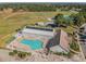 Aerial view of the community clubhouse, swimming pool, parking area, and green space with recreation facilities at 10805 Keys Gate Dr, Riverview, FL 33579