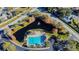 Aerial view features community pool, pond with fountain, landscaping, and surrounding neighborhood streets at 10805 Keys Gate Dr, Riverview, FL 33579