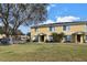 Two-story yellow townhome with grassy yard and trees at 10805 Keys Gate Dr, Riverview, FL 33579