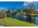 Scenic view of the community pond with a fountain, lush greenery, and mature trees around the perimeter at 10805 Keys Gate Dr, Riverview, FL 33579