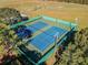 Aerial shot featuring meticulously maintained community tennis courts with vibrant green and blue surfaces at 10805 Keys Gate Dr, Riverview, FL 33579