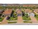Aerial view showcasing homes with clay tile roofs, brick driveways, and well-maintained landscaping in a lake community at 11125 Callisia Dr, Odessa, FL 33556