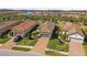 Aerial view of homes with clay tile roofs and brick driveways in a Primary planned community with lakes and landscaping at 11125 Callisia Dr, Odessa, FL 33556