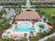 Community clubhouse aerial, featuring a luxurious pool, relaxing lounge areas, palm trees, and manicured landscaping for residents to enjoy at 11125 Callisia Dr, Odessa, FL 33556