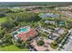 Stunning aerial of a community clubhouse, complete with a refreshing pool, tennis courts, and lush landscaping for active lifestyles at 11125 Callisia Dr, Odessa, FL 33556