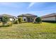 Lush backyard featuring manicured landscaping and neutral toned exterior, seamlessly blending with the natural surroundings at 11125 Callisia Dr, Odessa, FL 33556