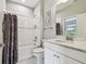 Well-lit bathroom with a bathtub, shower, and marble countertop sink at 11125 Callisia Dr, Odessa, FL 33556