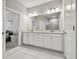 Bathroom with double sinks, granite counters, large mirror, and tiled floors at 11125 Callisia Dr, Odessa, FL 33556