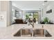 Kitchen with stainless sink and views into the bright and open living room at 11125 Callisia Dr, Odessa, FL 33556