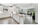 Open kitchen with stainless appliances, white cabinets, bar seating, and view of the living room at 11125 Callisia Dr, Odessa, FL 33556