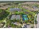 Aerial view of the community tennis courts and lakes surrounded by green trees and landscaping for an active lifestyle at 11125 Callisia Dr, Odessa, FL 33556