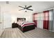 Bright bedroom with ceiling fan and wood-look flooring at 11828 Bingham Dr, Port Richey, FL 34668