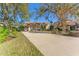 Tan house with a three-car garage and lush landscaping at 125 Falling Water Dr, Brandon, FL 33511