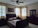 Main bedroom with a dark brown sleigh bed, dresser, and ceiling fan at 13504 Red Ear Ct, Riverview, FL 33569