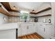 Modern white kitchen with wood shelving, quartz countertops, and stainless steel appliances at 1511 Prescott S St, St Petersburg, FL 33712