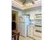 White kitchen cabinets, appliances, and a breakfast bar area at 1652 S Lake Ave # 2, Clearwater, FL 33756