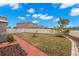 Landscaped backyard with a red brick walkway and a white fence at 16523 Myrtle Sand Dr, Wimauma, FL 33598