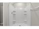 Clean shower with multiple shelves for toiletries at 16523 Myrtle Sand Dr, Wimauma, FL 33598