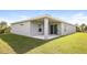 Covered patio with sliding glass doors, and grassy backyard at 19474 Strathcona Ave, Port Charlotte, FL 33954