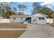 Newly renovated home with gray exterior, landscaping, and driveway at 2307 Mary Sue St, Largo, FL 33774