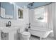 Bathroom with clawfoot tub, white tile, and black fixtures at 235 11Th Ne Ave, St Petersburg, FL 33701